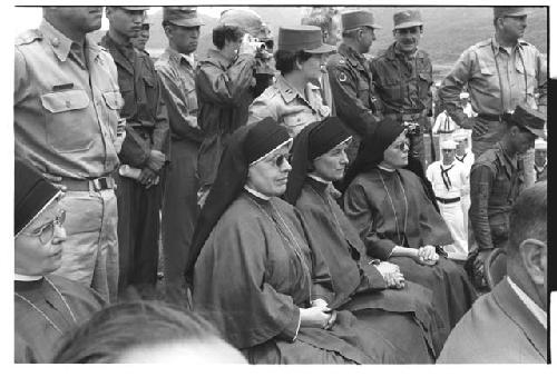 Maryknoll nuns sitting amongst soldiers at U.N. cemetery Memorial Day ceremony