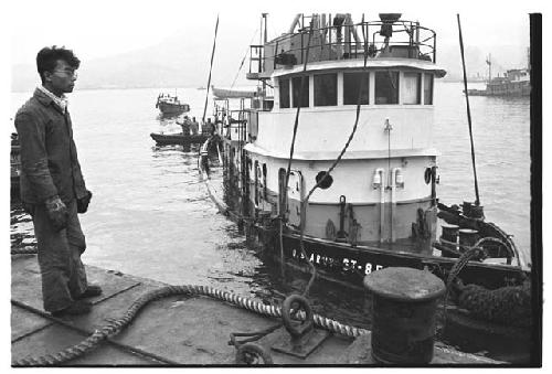 Man watching U.S. Army tugboat approaching dock