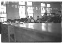 Several people in a room; focus on little girl looking up