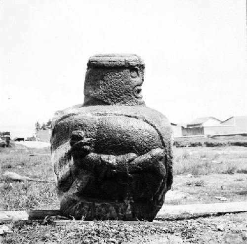 Stone sculpture of large seated pot-bellied figure