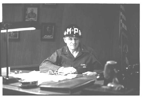 General Whitcomb posing while wearing a military police helmet