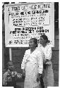 Two women and a child standing in front of sign