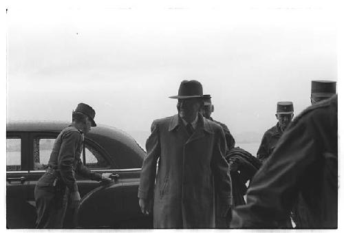 Under Secretary of the Army, Colonel Slezak, exiting car surrounded by American military personnel, including General Whitcomb (second from right)