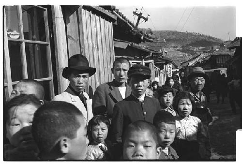 Group of adults and children on street, wearing a mix of Korean and Western styles