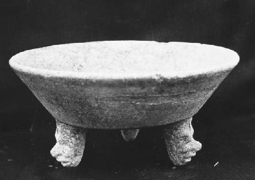 Tripod vessel with feet shaped as human heads - worn red slip.