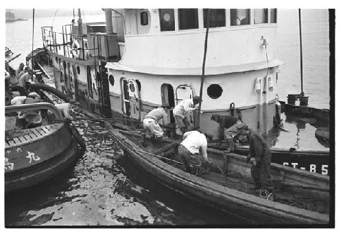 Small boat and tugboat assisting sinking U.S. Army tugboat