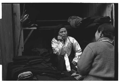 Woman sitting among bolts of cloth