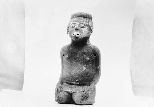 Kneeling, carved male figurine