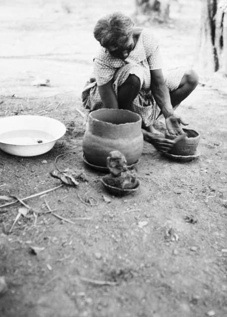 Pottery making, smoothing pottery after adding clay roll