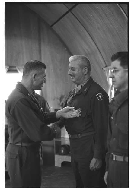 Man touching another soldiers' medal