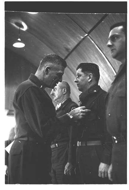 Man examining something on a soldier's uniform