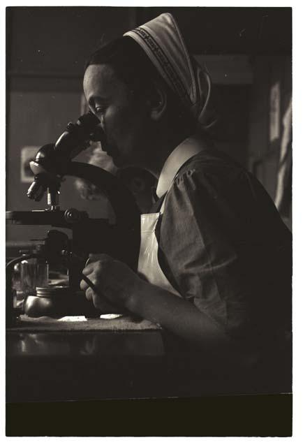 Nurse using microscope