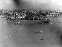 Ship and little boats going by a city