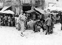 Man in uniform on street with market