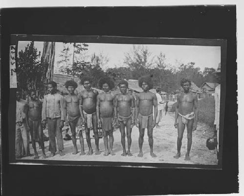 Group of men in front of huts