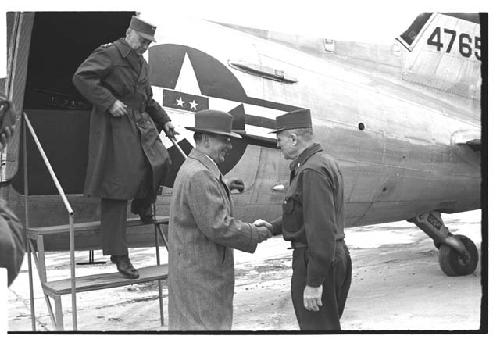 Colonel Slezak and General Whitcomb shaking hands outside airplane