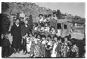 Children posing next to vehicle