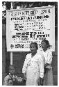 Two women and a child standing in front of sign