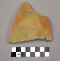 Body sherd with plain red slip exterior, brown slip interior, soil?