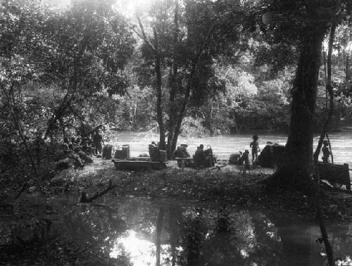 Group waiting on shore of flooded stream