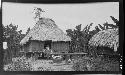 Man in front of hut in village