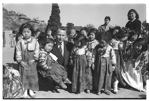 Man in a suit posing w/ children