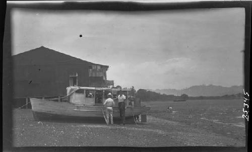 Men fixing boat in rural setting