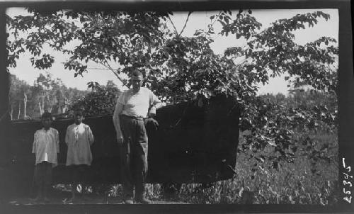 Man and children next to boat