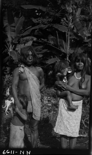 Family with small children standing in jungle