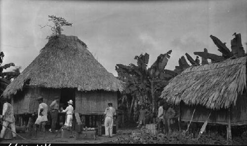 People standing outside of huts