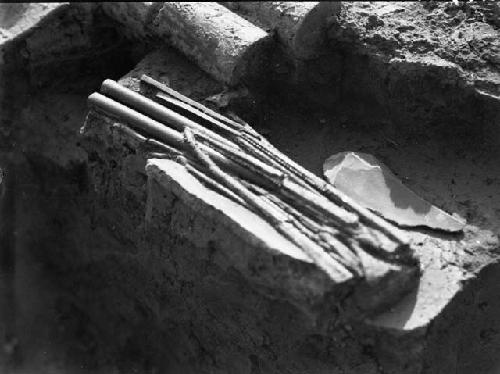 Arrows, ear ornaments and gold chisels in trench I, grave E