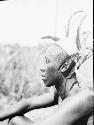 Profile view of man wearing grass crown with feathers