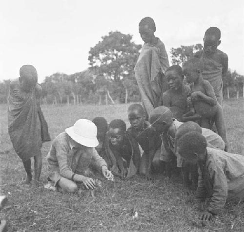 Children watching monkey being bottle fed after long march