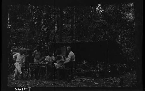 Men at table in jungle