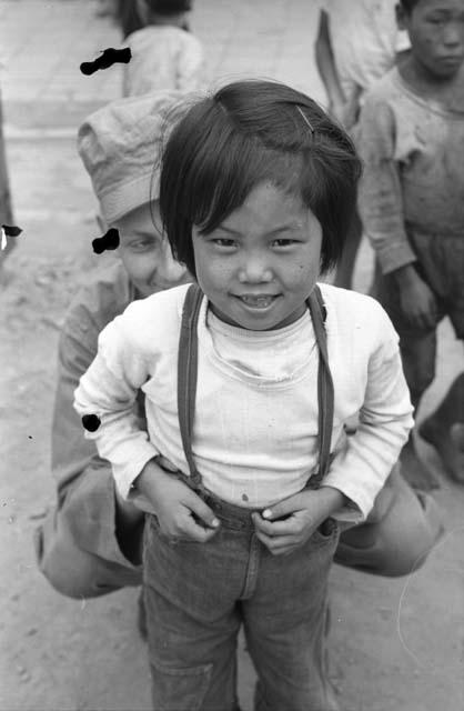 Child standing in front of kneeling soldier