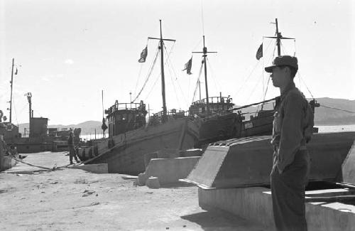 Man standing near ships at shipyard