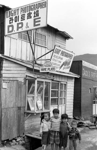 Four children in front of photography shop