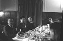 Men sitting at table in Dining Hall.