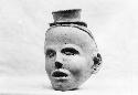 Earthen jar in the shape of a human head and face