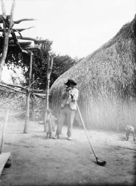 Man playing large Mapuche trumpet