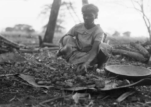 Woman beating clay to make pottery