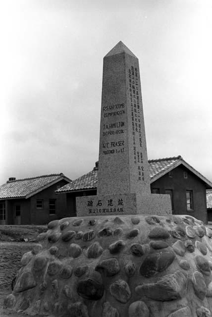 Stone monument (monolith) with Chinese and English inscribed on sides.