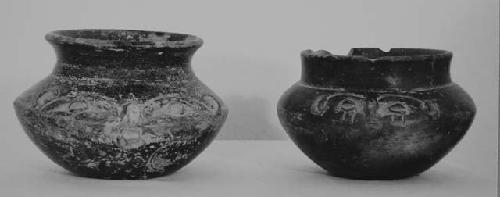 Two small black vessels with human face