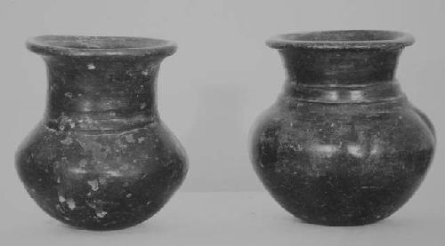 Two small polished black jars