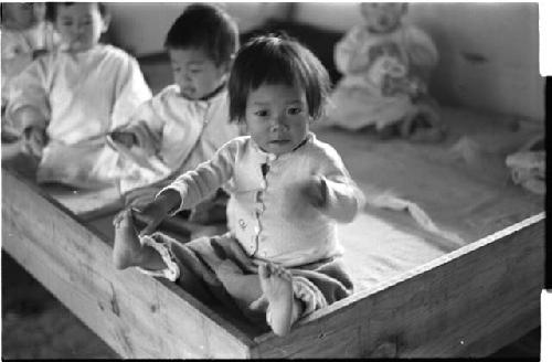 Baby girl touching one of her feet