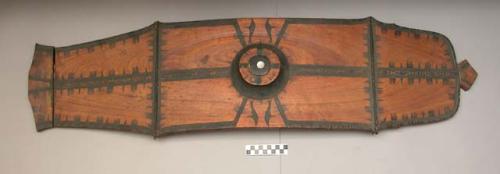 Wooden shield - brown with black; saw tooth and geometric design; +