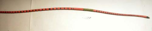 1 large bow of wood completely covered with grass and painted red and black