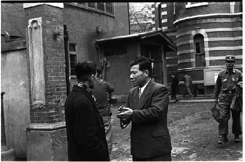 Two men speaking to each other outside a building