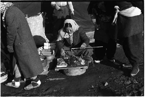 Woman sitting on the ground preparing food