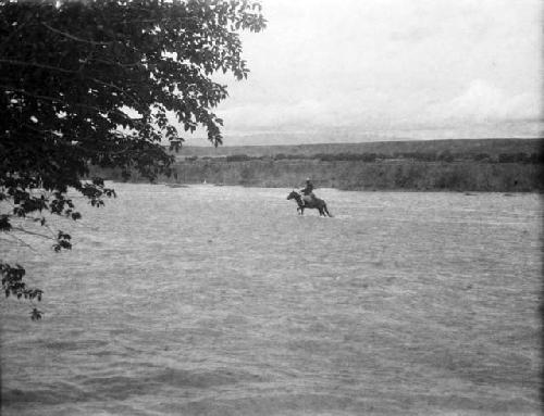 Horsemen fording river